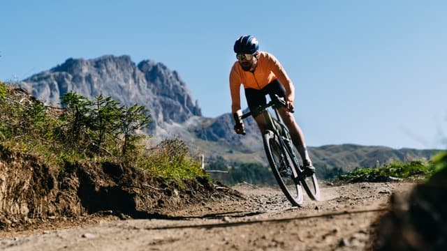 A person riding a bicycle in motion, demonstrating the balance and physics that keep two wheels stable while moving