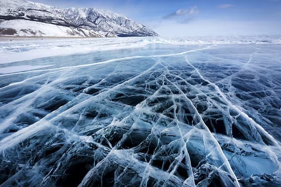 A close-up of an icy surface showing its smooth, glassy texture that drastically reduces friction underfoot